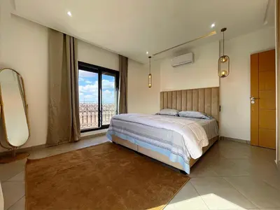 a bedroom with a large bed and a large window at Bewelcome in Marrakech