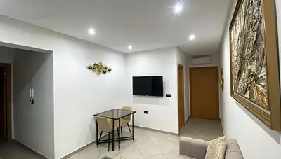 a living room with a table and a tv on a wall at Bewelcome in Marrakech