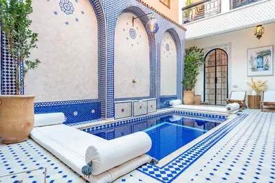 a pool in a house with blue and white tiles at Riad Olma in Marrakech