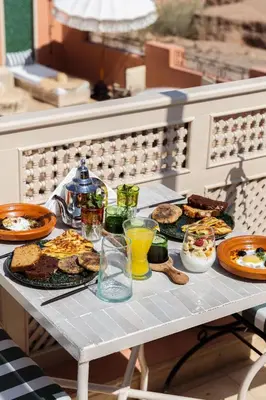 a table with plates of food and drinks on it at Riad Olma in Marrakech