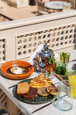 a table with a plate of breakfast food on it at Riad Olma in Marrakech