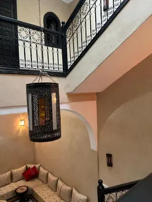 a chandelier hanging from a staircase with a couch at Riad Marrakech in Marrakech