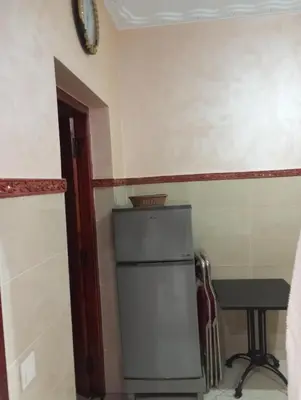 a small kitchen with a refrigerator and a table at dar immi in Marrakech