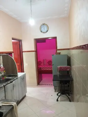 a kitchen with a pink door and a clock on the wall at dar immi in Marrakech