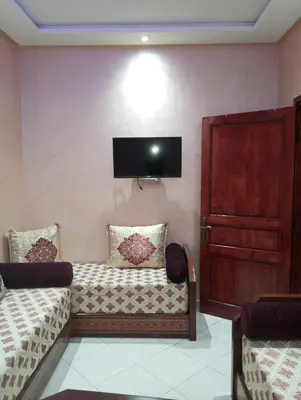 a room with a couch and a tv on the wall at dar immi in Marrakech