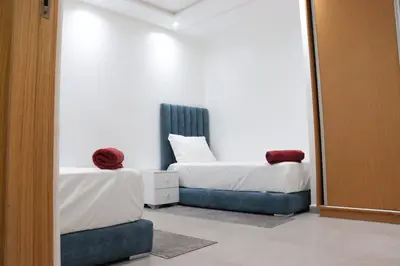 a bedroom with two beds and a mirror at appartement 3 chambres gueliz only families in Marrakech