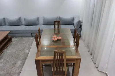a dining room table with chairs and a couch at appartement 3 chambres gueliz only families in Marrakech