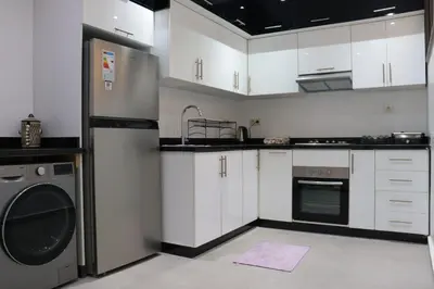 a kitchen with white cabinets and a washer and dryer at appartement 3 chambres gueliz only families in Marrakech