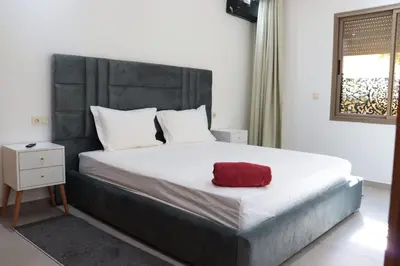 a bedroom with a large bed with a red pillow on it at appartement 3 chambres gueliz only families in Marrakech