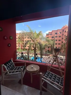 a balcony with two chairs and a table and a window at Appartement avec piscine in Marrakech