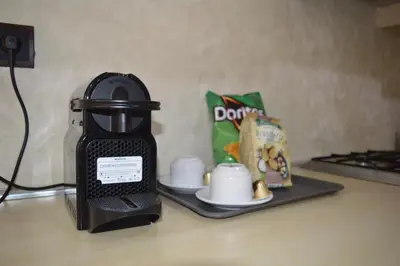 a coffee maker sitting on top of a counter with cups at Appartement avec piscine in Marrakech