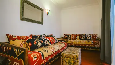 a living room with two couches and a mirror at Riad KAN ZAMAN in Marrakech
