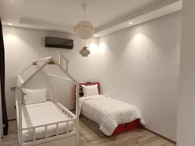 a small bedroom with a bed and a crib at Luxurious villa in Marrakech