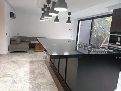 a kitchen with a black counter top and a couch at Luxurious villa in Marrakech