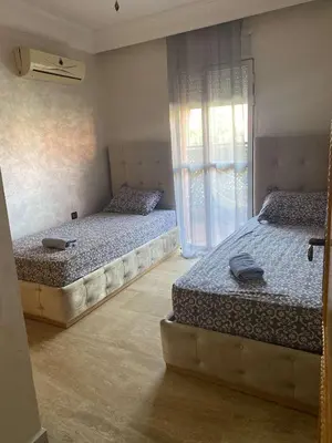 two twin beds in a room with a window at Appartement sur Guéliz in Marrakech