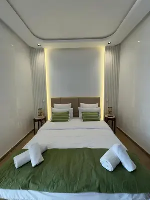 a bedroom with a large bed with white sheets and pillows at Appartement Siniya Cosy à Marrakech in Marrakech