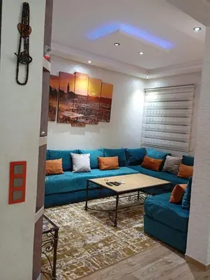 a living room with a blue couch and a table at Apartment Marrakech in Marrakech