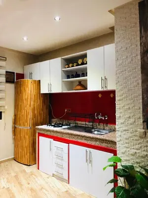 a kitchen with red and white cabinets and a refrigerator at Apartment Marrakech in Marrakech