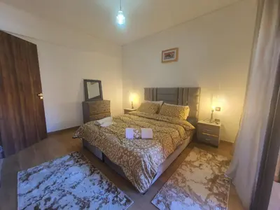a bedroom with a large bed and two night stands at Bonheur partagé 2 in Marrakech