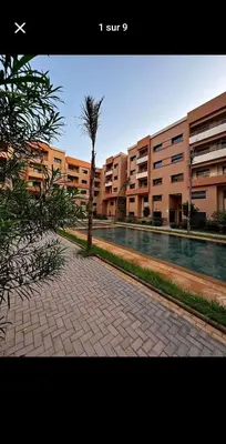 a palm tree on a sidewalk in front of a building at Bonheur partagé 2 in Marrakech