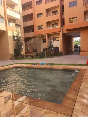 a swimming pool in front of a building at Bonheur partagé 2 in Marrakech