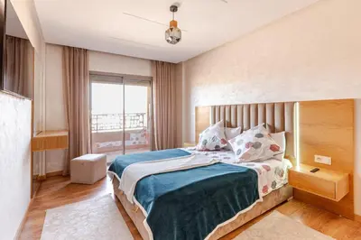 a bedroom with a bed and a large window at Spacieux 3 chambre au Coeur de Marrakech in Marrakech