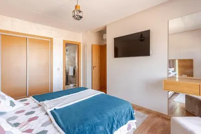 a bedroom with a bed and a television on the wall at Spacieux 3 chambre au Coeur de Marrakech in Marrakech