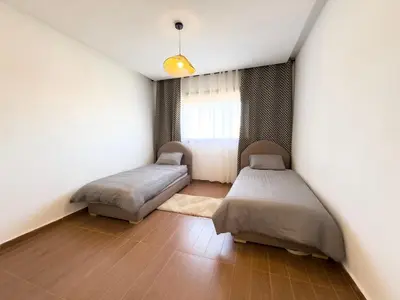 a bedroom with two beds and a window at Appartement tout confort à Marrakech avec Piscine et Capacité 4 Personnes in Marrakech
