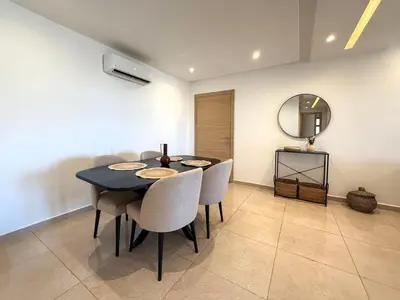 a dining room with a table and chairs and a mirror at Appartement tout confort à Marrakech avec Piscine et Capacité 4 Personnes in Marrakech
