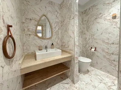 a bathroom with a sink and a mirror and a toilet at Appartement tout confort à Marrakech avec Piscine et Capacité 4 Personnes in Marrakech