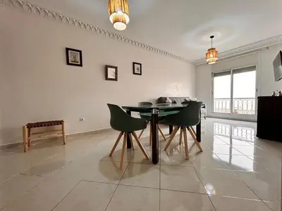a dining room with a table and green chairs at Lumière in Marrakech