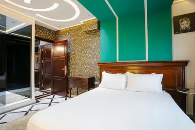 a bedroom with a bed and a green wall at Une Galerie Dans Le ciel - Hivernage Marrakech in Marrakech