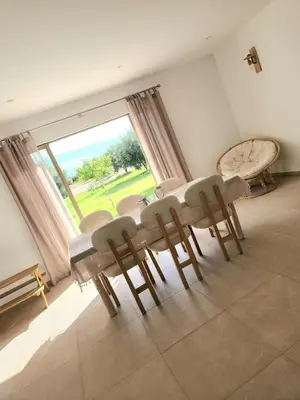 a dining room with a table and chairs and a large window at Villa ilyana, Atlas Villa in Marrakech