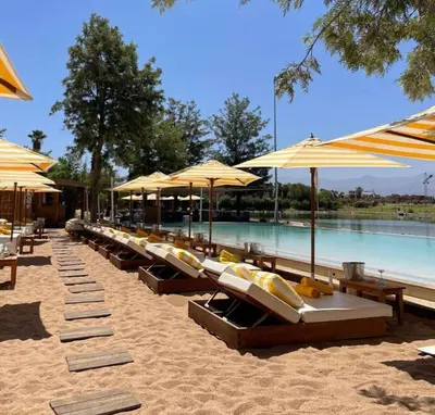 a row of lounge chairs and umbrellas on a beach at Villa ilyana, Atlas Villa in Marrakech
