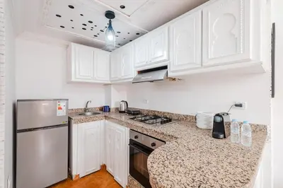 a kitchen with white cabinets and a stainless steel refrigerator at Cozy Studio Well Located Near Gueliz in Marrakech