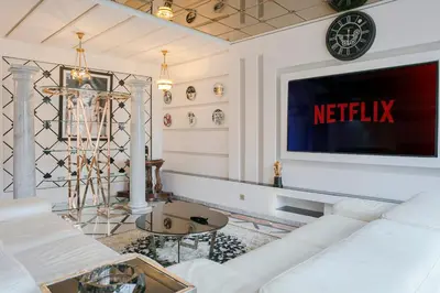 a living room with a white couch and a tv at Maison Elysium Hivernage Marrakech in Marrakech