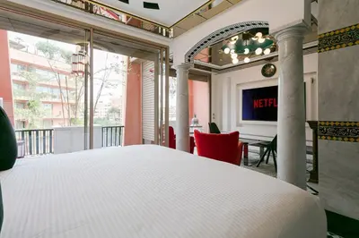 a bedroom with a bed and a table with a television at Maison Elysium Hivernage Marrakech in Marrakech
