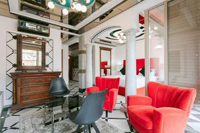 a living room with red chairs and a mirror at Maison Elysium Hivernage Marrakech in Marrakech