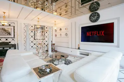 a living room with a white couch and a tv at Maison Elysium Hivernage Marrakech in Marrakech