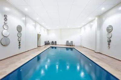 an indoor swimming pool with blue water in a room at Appartement élégant et cosy in Marrakech