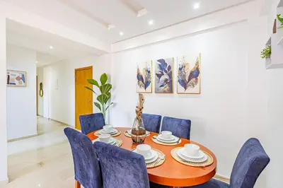 a dining room with a wooden table and blue chairs at Appartement élégant et cosy in Marrakech