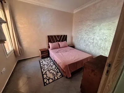 a small bedroom with a bed with pink sheets at Charming Apartment at Marrakech in Marrakech