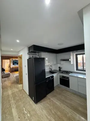 a kitchen with a black refrigerator in a room at Appartement Plaza Sunset in Marrakech