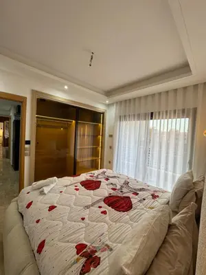 a bedroom with a large bed with red roses on it at Appartement Plaza Sunset in Marrakech