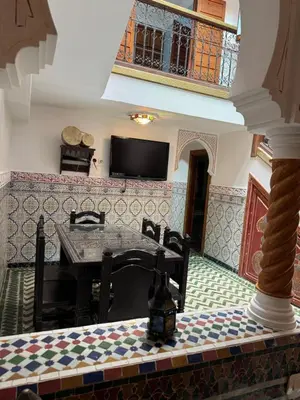 a dining room with a table and a tv at ASA House in Marrakech