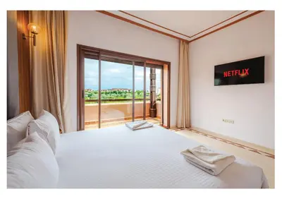 a bedroom with a white bed with a exit sign at Villa Iris Jaccuzi, Piscine 20min Centre in Marrakech