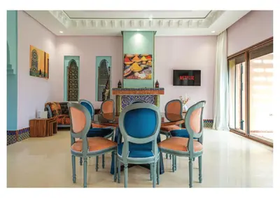 a room with a table and chairs and a fireplace at Villa Iris Jaccuzi, Piscine 20min Centre in Marrakech