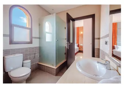 a bathroom with a toilet and a sink and a shower at Villa Iris Jaccuzi, Piscine 20min Centre in Marrakech