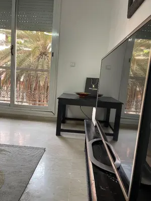a living room with a tv and a table at Spacious Vibrant Apartment Marrakech Central - Prime Lifestyle Group in Marrakech