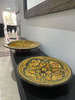 two plates sitting on top of a counter at Spacious Vibrant Apartment Marrakech Central - Prime Lifestyle Group in Marrakech